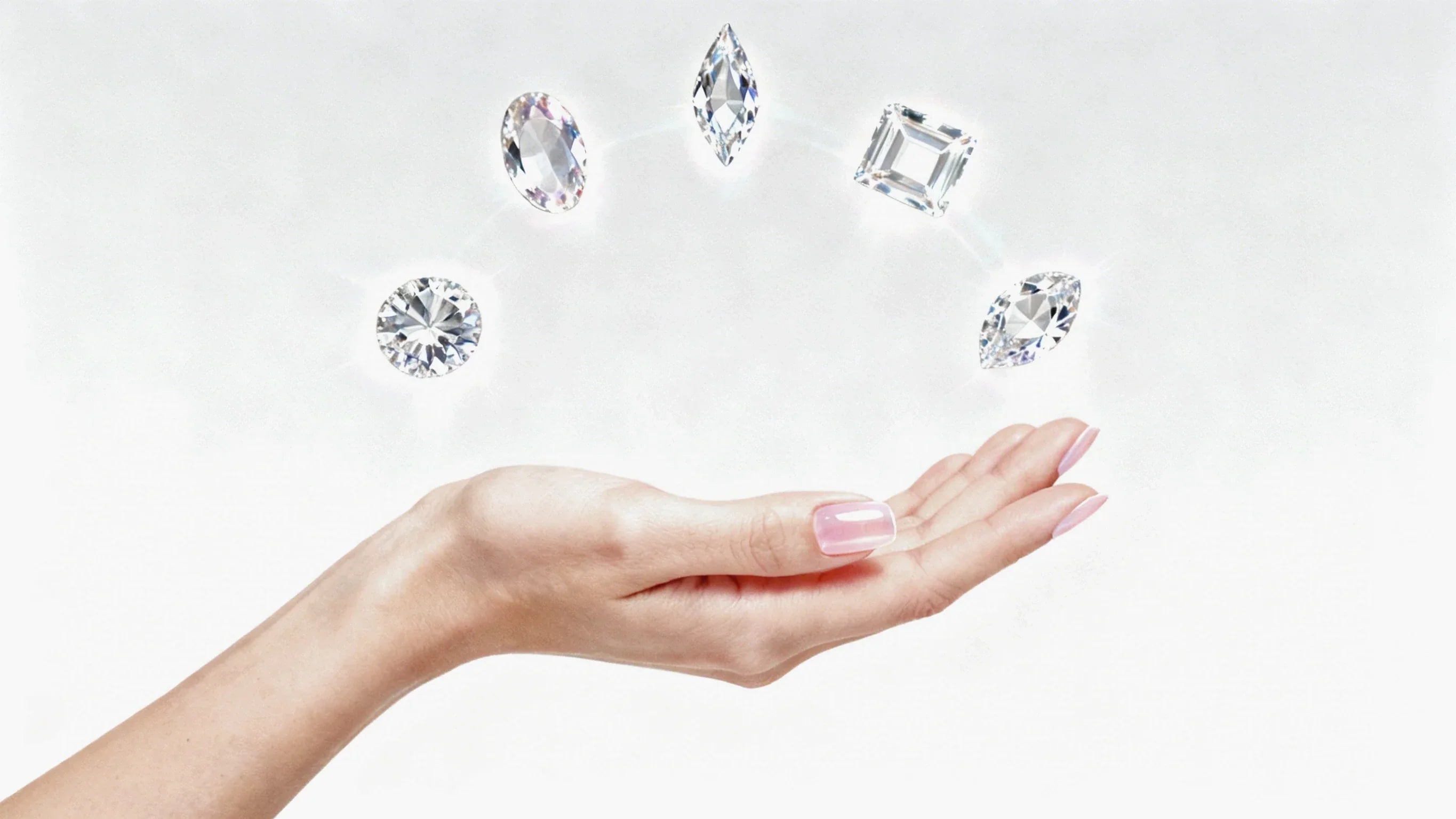 Hand with polished nails showcasing five different lab-grown diamond shapes on a white background